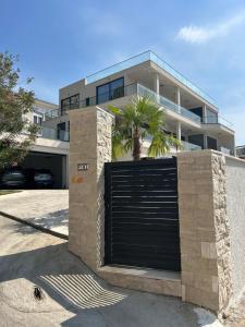 a black garage door with a palm tree in front of a building at Villa Mr Richard in Sutomore