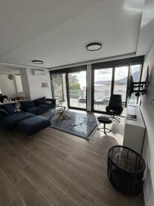 a living room with a blue couch and a large window at Villa Mr Richard in Sutomore