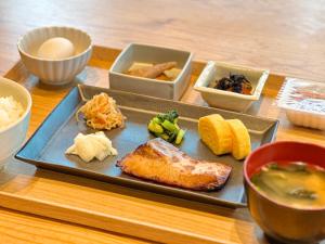 ein Teller mit Essen auf einem Tisch mit Schüsseln mit Essen in der Unterkunft Hotel Sun Road in Amakusa
