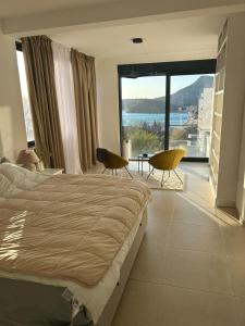 a bedroom with a bed and two chairs and a large window at Villa Mr Richard in Sutomore +32 photos