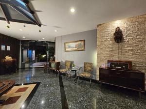 a living room with a fireplace and a table and chairs at Baan Suksiri Hotel Hua Hin in Hua Hin