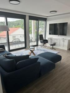 a living room with a blue couch and a large window at Villa Mr Richard in Sutomore