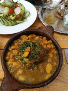 a table with a dish of food with beans and meat at Hotel El Golla in Er Rachidia