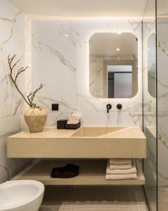 a bathroom with a sink and a mirror at PortoVista Luxury Urban Suites by BiNoBi! in Thessaloniki +54 photos
