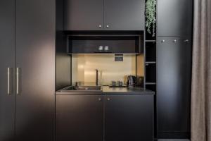 a kitchen with black cabinets and a sink at Budapest Cereja Boutique in Budapest