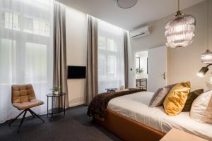 a bedroom with a bed and a chair at Budapest Cereja Boutique in Budapest