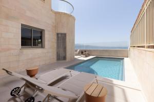 a villa with a swimming pool and a patio at Villa Vibes Eilat - Sea 40 Garden Apartment with Private Pool in Eilat