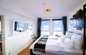 a bedroom with a bed and two windows at Suite im Zentrum Süd-Balkon Parken in Bad Lippspringe