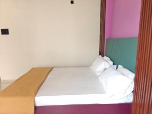 a bedroom with a bed with colorful walls at Hotel Jagdamb Kolhapur in Kolhapur
