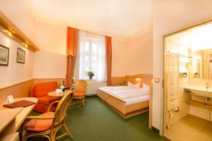 ツィノヴィッツにあるHotel Dünenschloss mit Private Spaのベッドとテーブルと椅子のあるホテルの部屋 +29枚の写真