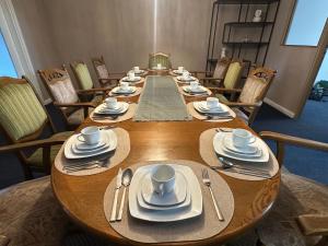 a long wooden table with plates and napkins on it at City Apartment Hamburg Work Relax Repeat in Hamburg