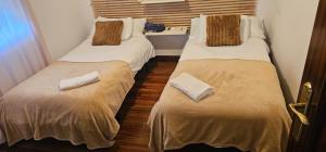two twin beds in a small room with at URA Agua Apartamento 2 in Sopuerta