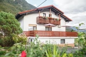 a white house with a balcony with umbrellas at Apartment Kolman in Tolmin