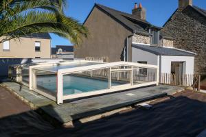 a swimming pool with a bridge over a house at Azur Cancale in Cancale