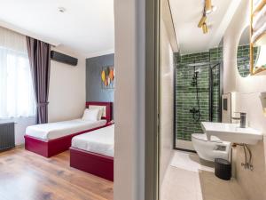a bathroom with two beds and a sink and a toilet at Perazre Hotel in Istanbul