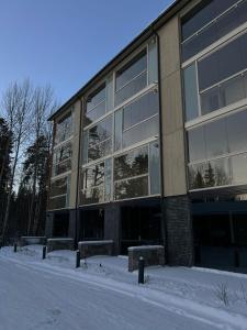 a large building with snow in front of it at Helsinki Airport Apartment Stay in Vantaa