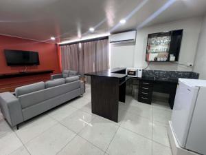 a room with a desk and a couch and a tv at Hotel Takia in Labasa