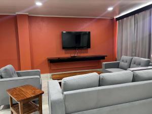 a living room with two couches and a flat screen tv at Hotel Takia in Labasa +9 photos