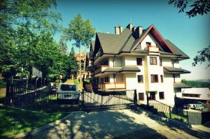 a large house with a fence in front of it at Apartament Kasprowy Jaszczurówka in Zakopane