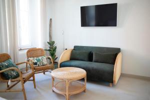 a living room with a couch and chairs and a table at Hôtel de la Béroche in Saint Aubin Sauges