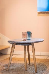 a wooden table with two glasses on top of it at Le petit ordinaire in Le Cours
