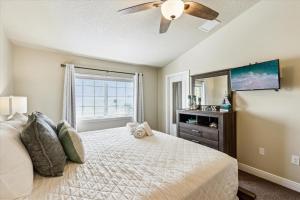 a bedroom with a bed with a ceiling fan and a mirror at Cape Crossing 103 in Merritt Island +45 photos