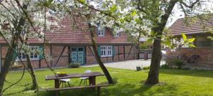 a picnic table in front of a house with trees at besinndich in Nebelin
