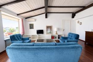 a living room with two blue chairs and a tv at Attico Zamagna in Cesenatico