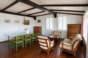 a dining room with a green table and chairs at Attico Zamagna in Cesenatico