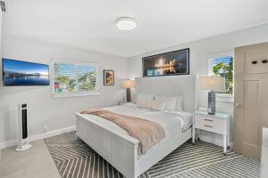 a white bedroom with a bed and two windows at 126 Deleon Rd in Cocoa Beach