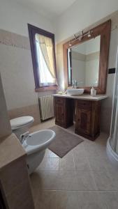 a bathroom with a sink and a toilet and a mirror at The Cozy Nest in Santa Maria a Monte +8 photos