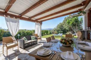 an outdoor patio with a table and chairs at Bellavista Vacation stunning Tavolara sea view terrace in Olbia