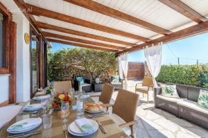 an outdoor dining room with a table and chairs at Bellavista Vacation stunning Tavolara sea view terrace in Olbia