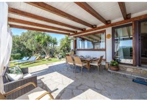 a patio with a table and chairs on it at Bellavista Vacation stunning Tavolara sea view terrace in Olbia