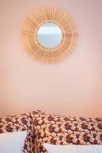 a mirror hanging on a wall above a couch at Le petit ordinaire in Le Cours