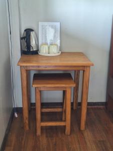 a wooden table with mugs on it with a stool at champa resort in Don Det