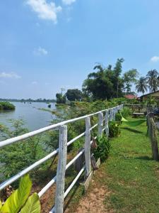 a fence next to a body of water at champa resort in Don Det
