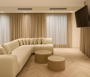 a living room with a large white couch and two tables at VILLA Leonard וילה לאונרד אילת in Eilat