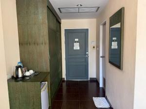a hallway with a blue door in a room at Baan Suksiri Hotel Hua Hin in Hua Hin