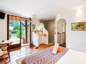 a room with a bed and a kitchen and a table at chambres d'hôtes villa OZ in Bidart