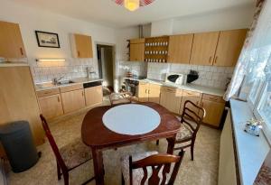 a small kitchen with a table and chairs in it at Strand Haus Am Walde in Trassenheide