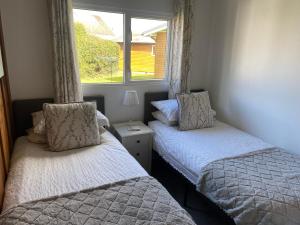 two beds in a room with a window at Chalet Thirty Two in Seaton