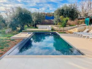 a swimming pool in a yard with chairs and trees at Amavi Luxury Tent Corfu in Víngla