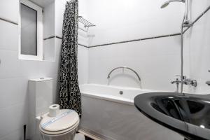 a white bathroom with a toilet and a sink at Hotel European 8 in Odesa