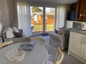 a living room with a couch and a table and a kitchen at Chalet Thirty Two in Seaton +20 photos