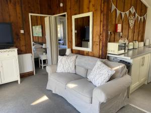 a living room with a white couch and a television at Chalet Thirty Two in Seaton