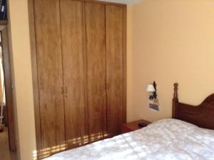 ベトレンにあるTuca d'Aranのベッドルーム1室(ベッドの横に大きな木製キャビネット付)