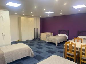 a room with two beds and a purple wall at GUM University Apartment in Ulaanbaatar