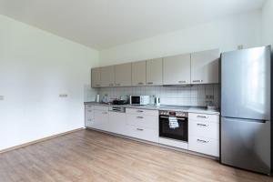 a kitchen with white cabinets and a stainless steel refrigerator at Monteurzimmer Jerichow in Jerichow