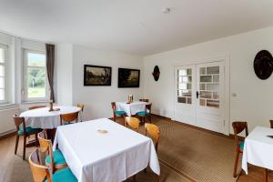 a dining room with white tables and chairs and windows at Monteurzimmer Jerichow in Jerichow +3 photos